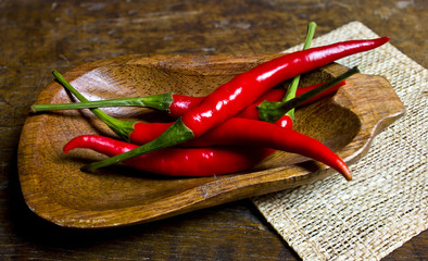 Red hot chilli on wooden dish with fiberglass flooring