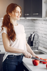 Elegants girl in a kitchen. Woman with fruits. Lady in white blouse