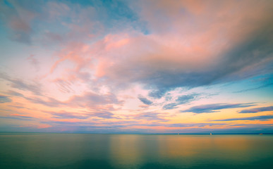 sunset over the sea with boats on horizon