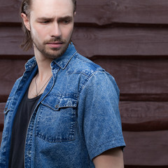 Portrait of handsome young man on wooden background.