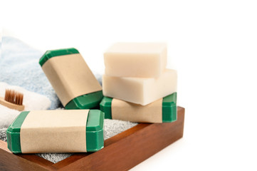 Handmade soap on wooden tray over white background.