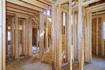 Beam built home under construction with wooden truss, post and beam framework.