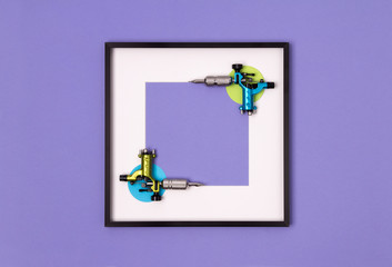 Tattoo machines in frame on purple background. Mock up for tattooing artist studio