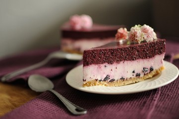 Homemade no baked blueberry cheesecake decorated with flowers on white plate
