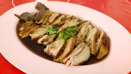 Asian style fresh sliced duck meat strewed with special black soy sauce on pink plate