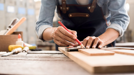 Carpenter working with equipment on wooden table in carpentry shop. woman works in a carpentry shop. - obrazy, fototapety, plakaty