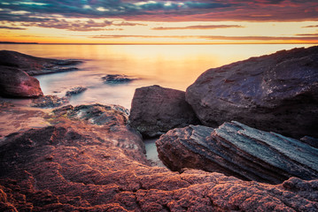 Fototapeta na wymiar Picturesque sunrise over a rocky beach.