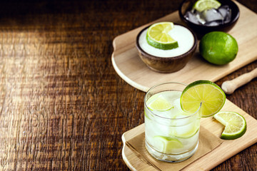 Caipirinha, drink from Brazil, typical of the Brazilian summer. Fruit drink with vodka or cachaça, on rustic wooden background and space for text.