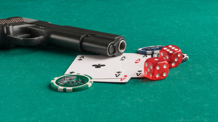 Poker chips, cards and gun on a green background. The concept of gambling and entertainment. Casino...
