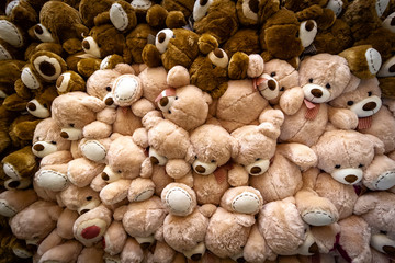 A large pile of teddy bears toys as a background.