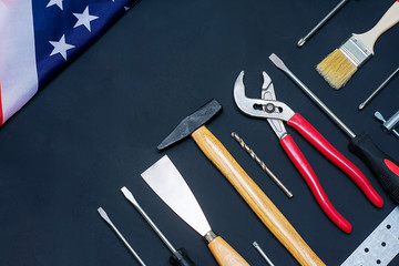 USA Labor Day. Different tools and american flag on a black background