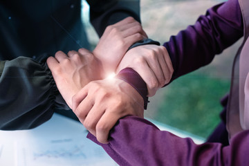 Humanhands touching together,collaborator,union,sign and symbol of power and success,Lens flare effect
