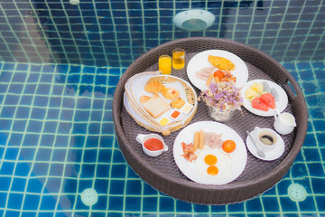 Breakfast set floating around swimming pool