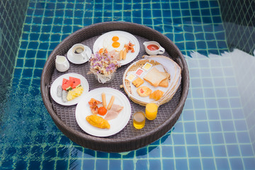 Breakfast set floating around swimming pool