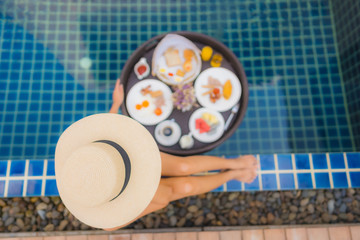 Portrait beautiful young asian woman happy smile relax with breakfast floating around swimming pool