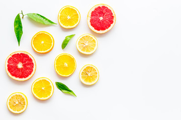 Citrus slices frame - lemons, grapefruits, leaves - on white background top-down copy space