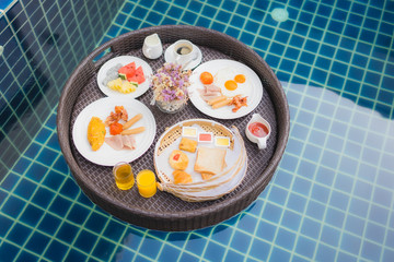 Breakfast set floating around swimming pool