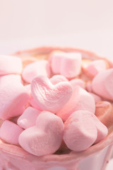 Fototapeta na wymiar strawberry pink color hot chocolate with heart shaped marshmallows 