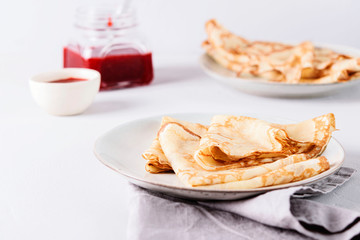 Crepes with strawberry jam on grey background. Pancake week, mardi gras, maslenitsa holidays. Selective focus