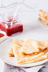 Crepes with strawberry jam on grey background. Pancake week, mardi gras, maslenitsa holidays. Selective focus