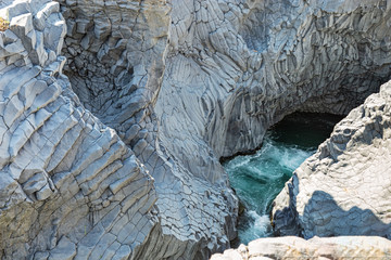 Alcantara Gorge and Alcantara river Park in Sicily island,  Italy. Black walls. Walls made of volcanic stone along river bed.