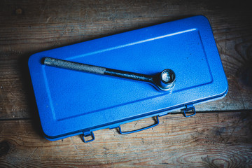 A socket wrench on a blue tool box