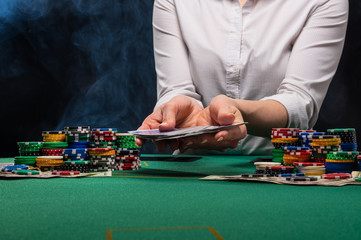 Girl dealer, croupier hands out poker cards in a casino, concept for business games, casino