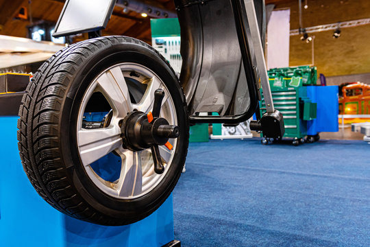 A car wheel on an automated car wheel balance machine in the garage.