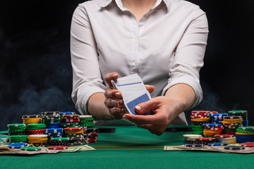 Girl dealer, croupier hands out poker cards in a casino, concept for business games, casino