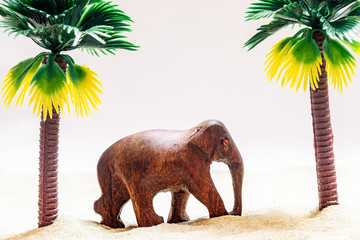 Wooden elephant. Symbolic beach and palm trees