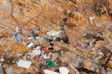 Plastic waste garbage and foam scrap on rock shore and sea beach