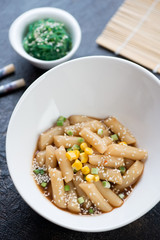Close-up of korean tteok-bokki or rice cakes served in a white bowl, studio shot
