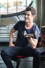 Fototapeta na wymiar Lifestyle playful man having fun Lifting dumbbell in gym exercise with work out program for healthy
