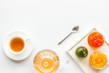 Fruit jam near tea on white kitchen desk frame copy space