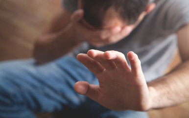 Caucasian man making stop gesture.