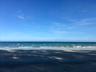Fototapeta na wymiar Scenery of empty sea beach sand and blue sky on summer sun day