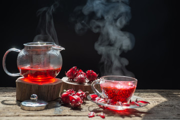 hot tea is poured from the kettle into a kettle with tea leaves redcurrant mandarin orange lemon,rosemary, mint.,hot food and healthy meal concept