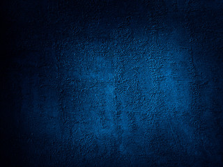 Dark blue grunge background. Rough grainy concrete wall surface texture. Close-up. Abstract blue...