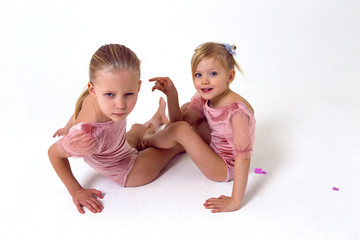 two sisters sitting on a white background