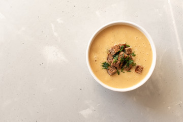 Tomato soup in a black bowl on grey stone background. Top view. Copy space.