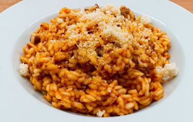 Traditional italian risotto with bolognese ragu and parmigiano reggiano cheese