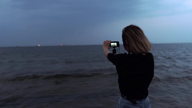 Girl shoots the ocean on camera