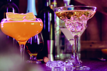 Two beautiful cocktails served on a wooden bar counter