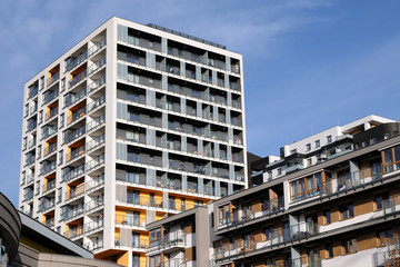 Facades of modern apartment buildings with balcony in contemporary residential district.