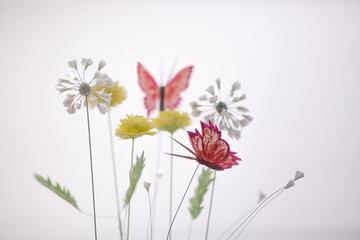 Spring composition with paper flowers and butterfly on white background