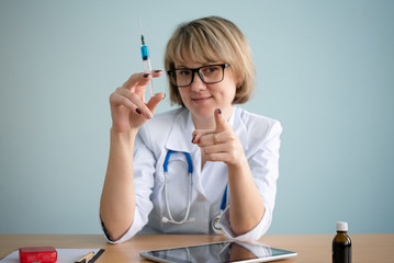 Woman a doctor with syringe in hand.