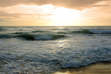 Beautiful sunset on tropical beach. The surf pounds the shore. Karon beach, Phuket, Thailand