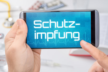 Smartphone mit dem Text Schutzimpfung auf dem Display