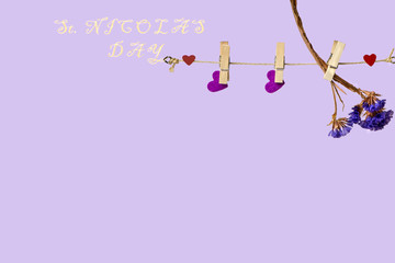 heart hanging on a clothespin on a rope and a lilac flower, background