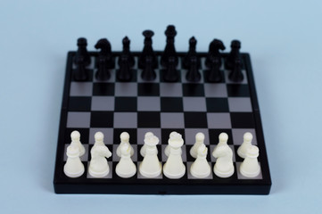 Chess on a blue background. Portable magnetic chess.